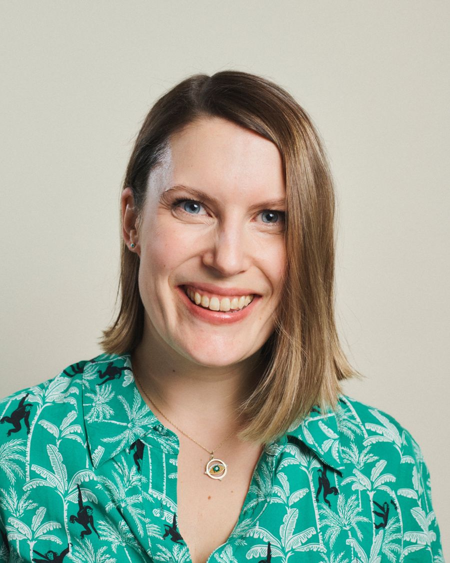 Kayleigh smiling, wearing a green palm-print shirt